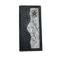 A Western Stakes Lone Star Long Wallet Black W Cowhair Basketweave featuring a textured basket weave design and a contrasting white fur-like panel. The edge of the white panel is wavy, and a silver star concho decorates the top right corner. White stitching borders this cowboy accessory's exterior.