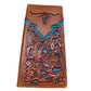 A **Western Stakes Floral Long Wallet Longhorn Teal Accent** featuring intricate embossed floral patterns and turquoise accents. The top flap is decorated with a raised bull skull motif, making it a perfect cowboy gift. Crafted from high quality leather, the edges are stitched with white thread, adding a neat finish to the artisanal design.