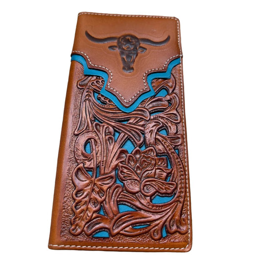 A **Western Stakes Floral Long Wallet Longhorn Teal Accent** featuring intricate embossed floral patterns and turquoise accents. The top flap is decorated with a raised bull skull motif, making it a perfect cowboy gift. Crafted from high quality leather, the edges are stitched with white thread, adding a neat finish to the artisanal design.