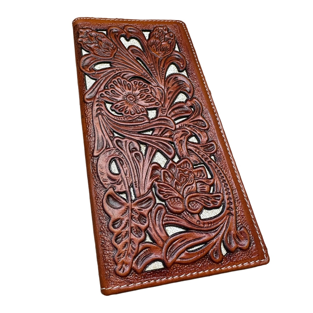 A Floral Leather Long Wallet Brown White by Western Stakes embossed with an intricate floral design. The dark brown leather contrasts with the light background, highlighting the detailed craftsmanship of the flowers and leaves on its surface. This checkbook style wallet features neatly stitched edges and a bull rider rodeo concho for added flair.