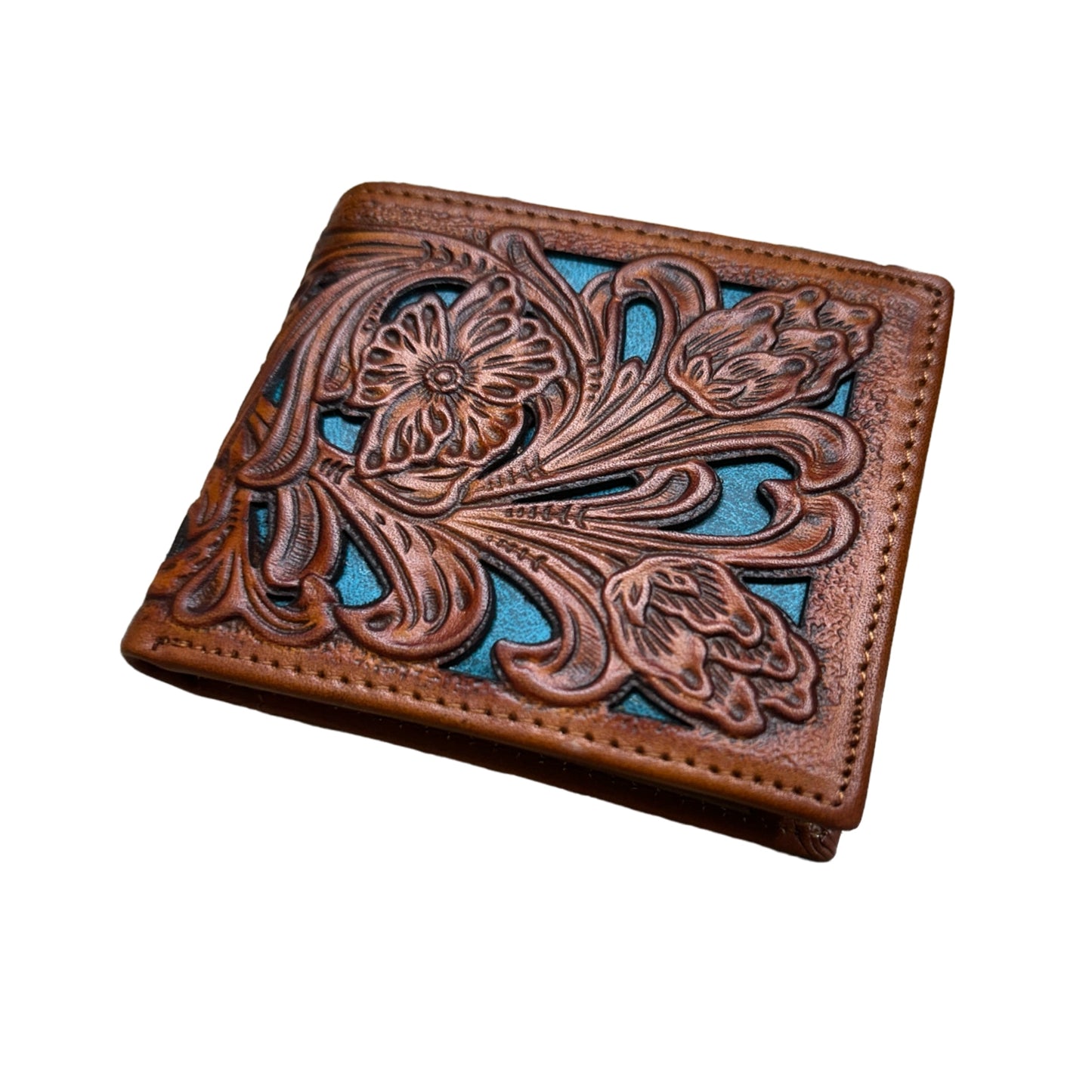 A closed brown leather wallet with an intricate floral cutout design embossed on the front. The background of the design features a teal accent, creating a striking contrast against the brown leather. This handcrafted Floral Leather Cowboy Wallet Brown & Teal by Western Stakes makes for perfect rodeo gifts, blending style and craftsmanship flawlessly.