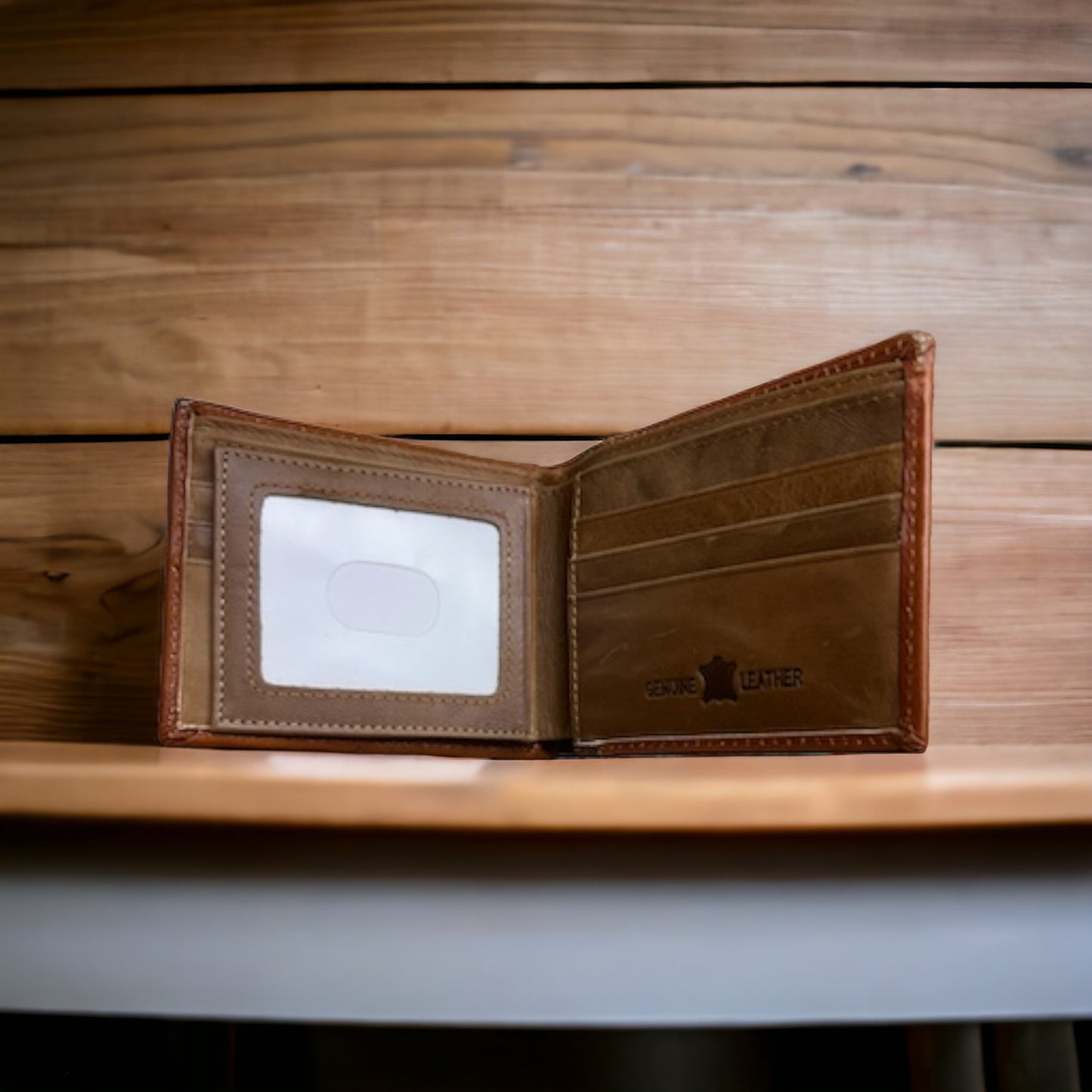 A Western Stakes Floral Leather Cowboy Wallet Brown & Teal is open and empty against a wooden background. The wallet has multiple card slots on the right, a transparent ID card slot on the left, and features a subtle floral cutout design. The words "GENUINE LEATHER" are visible on the bottom-right corner, perfect for rodeo gifts.