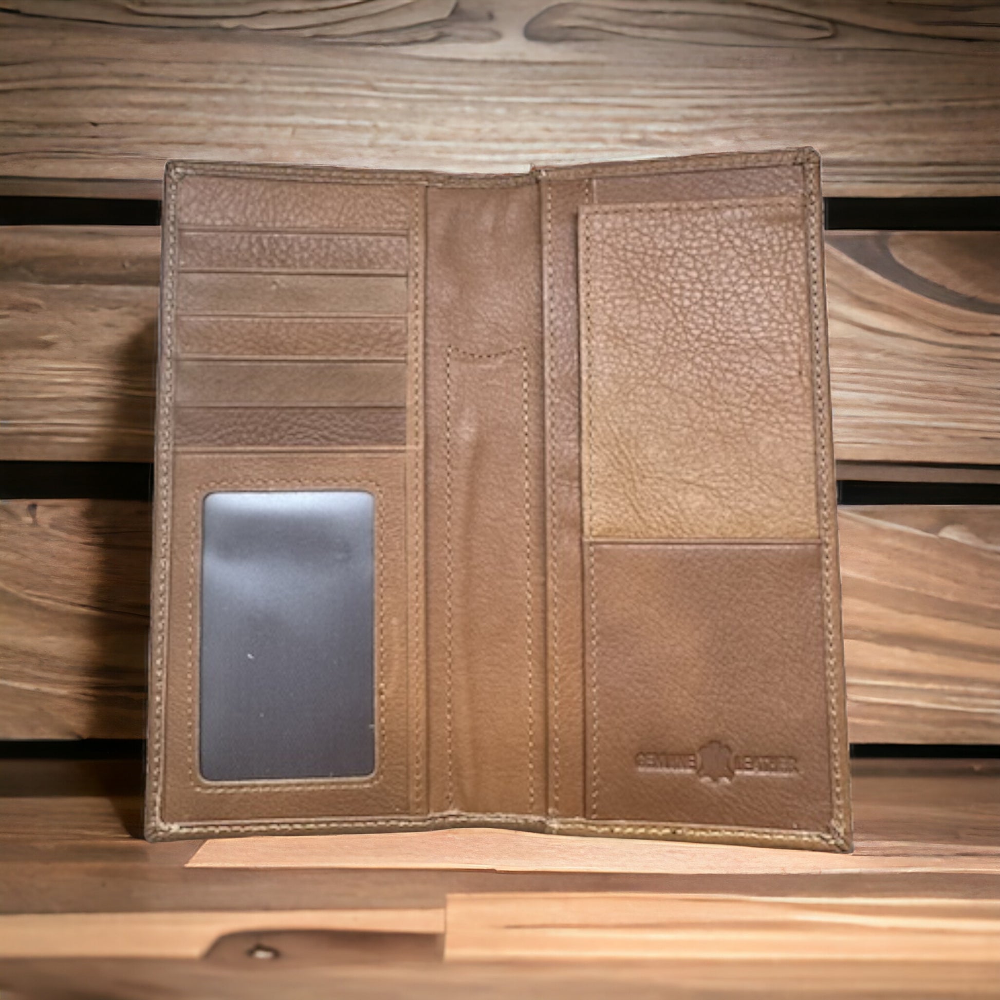 A Bull Rider Long Wallet W Cowhair Basketweave by Western Stakes, a quintessential cowboy accessory, is open on a wooden surface, revealing multiple card slots, a transparent ID holder, and two larger compartments for bills or documents. The wallet features stitching along the edges and a subtle embossed logo in the bottom right corner.