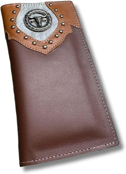 A brown leather wallet featuring a silver emblem and studs on a tan and gray leather patch at the top. The emblem depicts a stylized bull's head, reminiscent of a Longhorn. This western accessory also boasts visible stitching along the edges. Introducing the Longhorn Long Wallet Brown With Cowhair & Concho by Western Stakes.