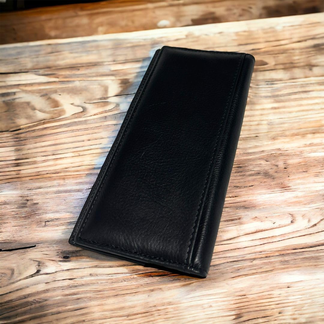 A black leather Bull Rider Long Wallet W Cowhair Basketweave by Western Stakes with a stitched border is placed on a wooden table with a textured surface. The bill holder is closed and has a sleek, minimalist design.