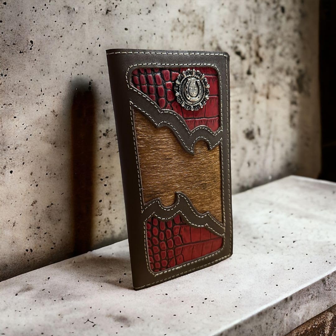 A unique Western Stakes Horseshoe Long Wallet Coffee Red Trim W Cowhair featuring a combination of high-end brown leather, red accents, and crocodile-textured panels, adorned with a metallic emblem. The wallet is placed upright against a textured concrete background.