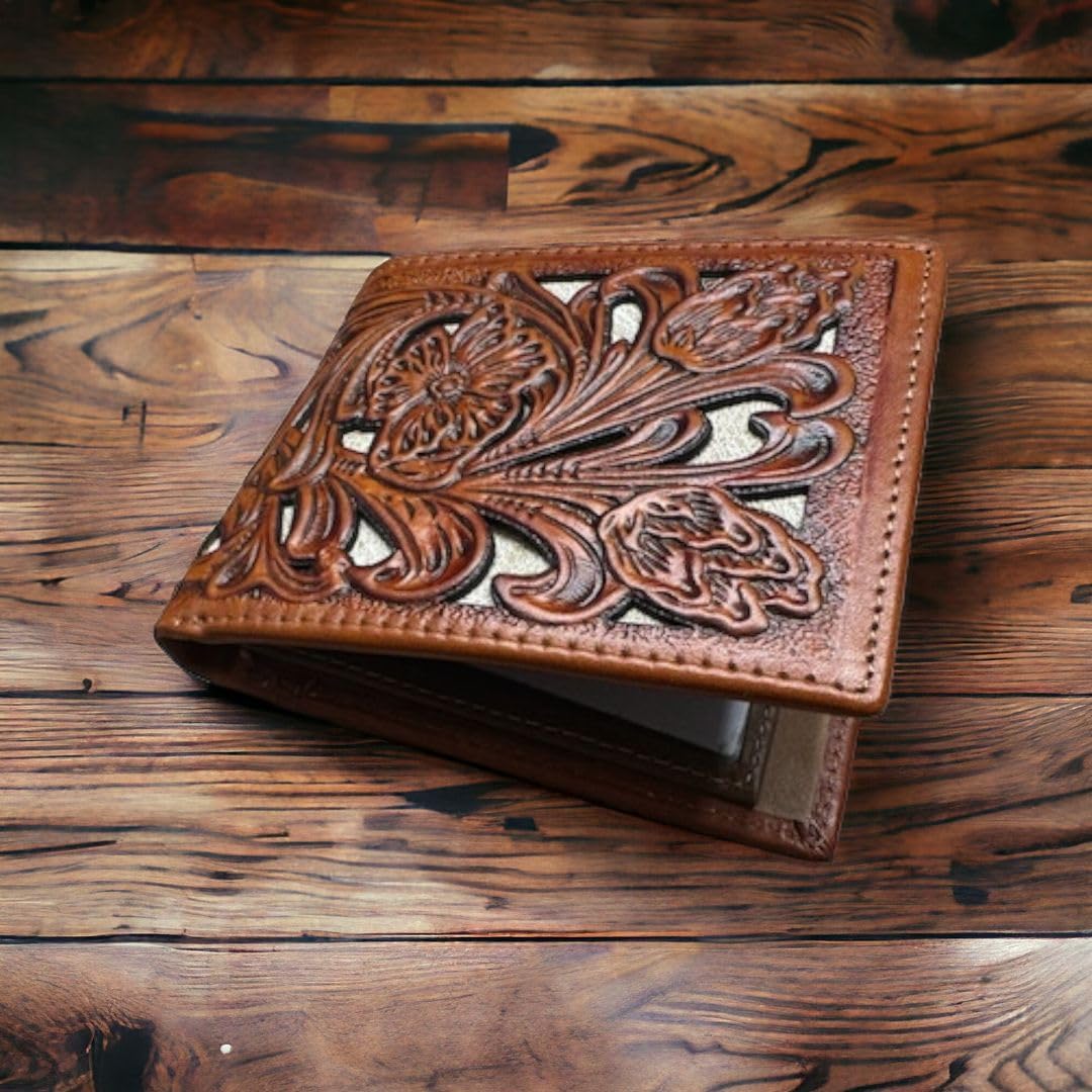 A **Western Stakes Floral Leather Cowboy Wallet Brown & Teal** with a handcrafted cowboy wallet feel and intricate floral cutout design is placed on a wooden surface. The detailed embossing on the wallet creates an elegant and sophisticated appearance.