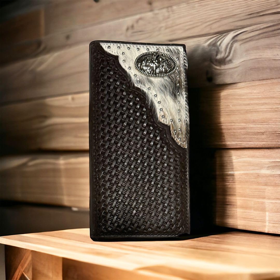 A rectangular, dark brown leather Bull Rider Long Wallet W Cowhair Basketweave by Western Stakes sits upright on a wooden surface. The top right corner features cowhide with stud accents and an ornate rodeo concho. The background is made of wooden planks, adding a rustic feel.