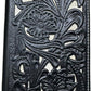 A rectangular black leather checkbook style wallet with intricate floral embossing, featuring detailed flowers and leaves. The design is raised and creates a textured pattern on the wallet's surface. The edges are neatly stitched, highlighting the craftsmanship of the item. This is the Floral Long Wallet Black White by Western Stakes.